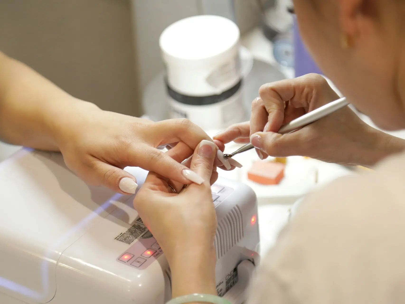 a woman getting her nails done at a nail salon